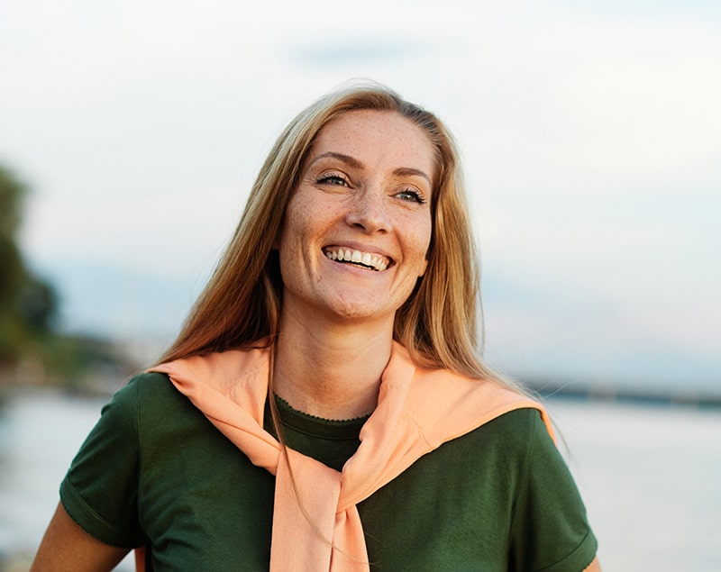 Happy-woman-by-the-river-smiling Emergency dentistry