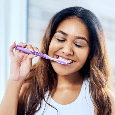 Woman brushing her teeth for better oral health