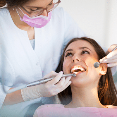 How often to see a dentist: the answer may surprise you 9 Woman smiling at the dentist while her teeth are worked on, representing how often to see a dentist